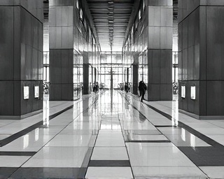 modern tile designs, sleek, emphasizing symmetry, photorealistic, lining a skyscraper lobby, highly detailed, with bustling movement, clear definition, monochrome shading, soft evening lighting, shot with a tilt-shift lens